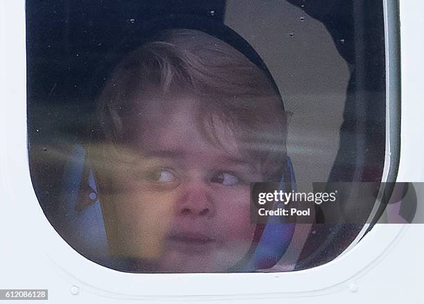 Prince George of Cambridge presses his face against the window as he leaves from Victoria Harbour aboard a sea-plane on the final day of their Royal...