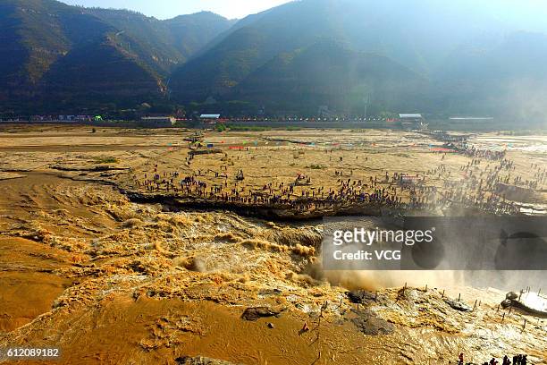 Aerial view of tourists visiting the Hukou Waterfall during the National Day holiday on October 2, 2016 in Yan'an, Shaanxi Province of China. The...