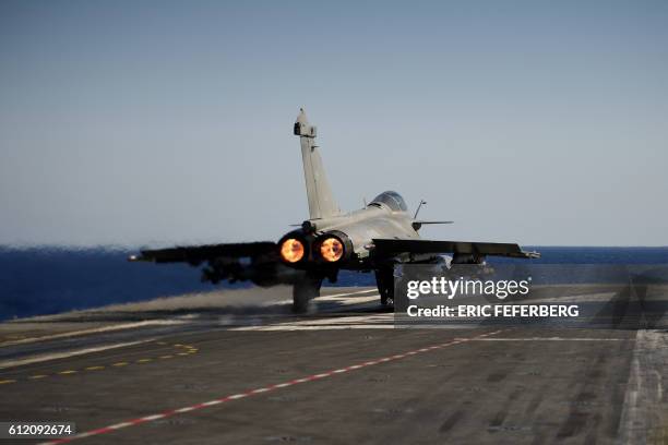 Marine Rafale jet fighter departs from the French aircraft carrier Charles de Gaulle on the Mediterranean Sea on October 2 as part of the Operation...