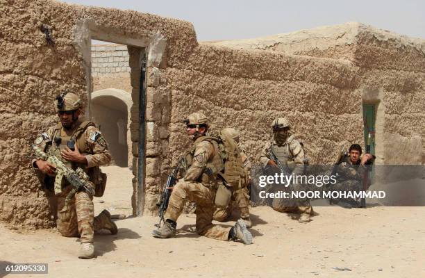 In this photograph taken on October 2 Afghan National Army commandos take position during a military operation in Helmand province.