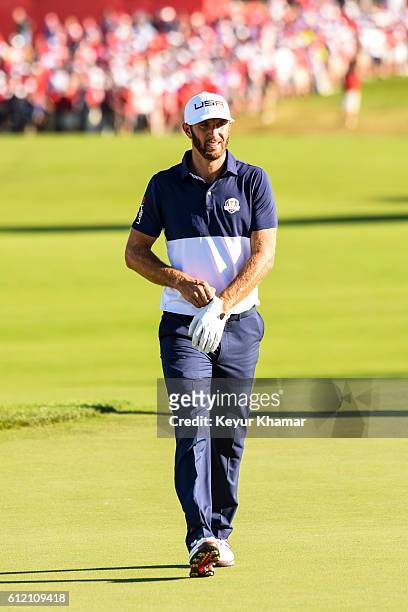 Dustin Johnson of Team USA puts on a glove as he walks to the 18th hole green during singles matches of the 2016 Ryder Cup at Hazeltine National Golf...