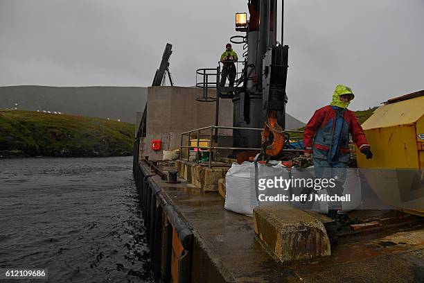 Jason and Stuart Taylor work the crain on the jetty on the Island of Foula on September 29, 2016 in Foula, Scotland. Foula is the remotest inhabited...