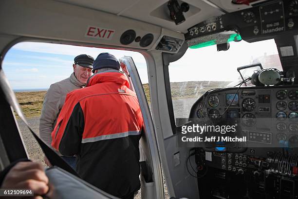 Jim Grear talks to the pilot of The Islander Aircraft at the airstrip on the Island of Foula on October 3, 2016 in Foula, Scotland. Foula is the...