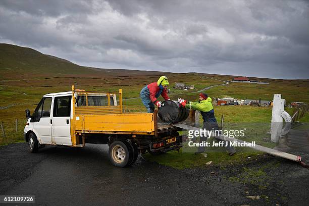 Jason and Stuart Taylor load a tar barrel onto a pick up on the Island of Foula on September 29, 2016 in Foula, Scotland. Foula is the remotest...
