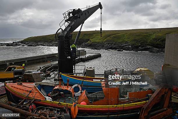 Jason and Stuart Taylor work the crain on the jetty on the Island of Foula on September 29, 2016 in Foula, Scotland. Foula is the remotest inhabited...
