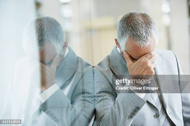 businessman with hand on his head - oliver eltinger stock-fotos und bilder