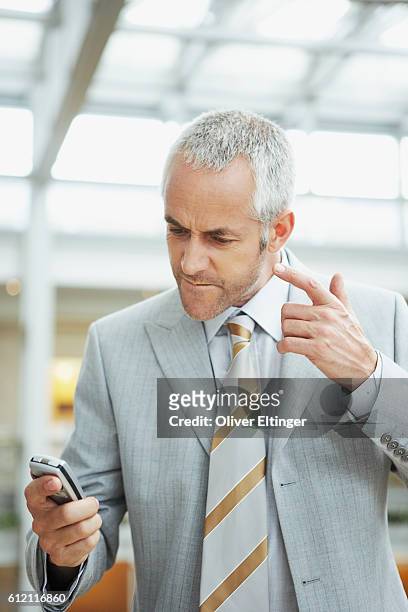 businessman reading text message - oliver eltinger fotografías e imágenes de stock