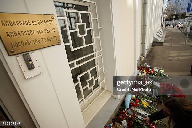 People place flowers for the victims of the Brussels attacks, near the Belgian embassy in Moscow, on March 23, 2016.