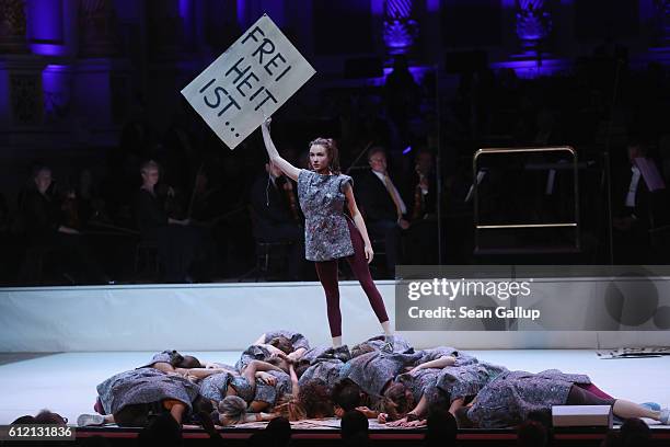 Dancer holds up a sign that reads: "Freedom is . . ." during a performance during celebrations to mark German Unity Day at the Semperoper opera house...