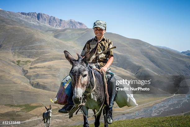 Boy is riding a donkey on the way to the camp of shepherds near Khinalig village, Quba region, Azerbaijan. He works as a shepherd with his father...