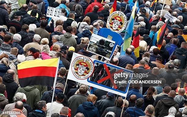 Supporters of the Pegida take part in a protest against German Chancellor Angela Merkel and her policy on October 3, 2016 in Dresden, eastern...