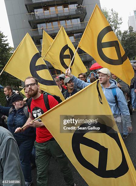 People carrying flags showing the symbol of the right-wing, pan-European Identitarian movement march with supporters of the Pegida movement on German...