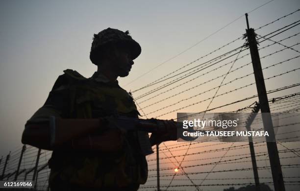 An Indian Border Security Force soldier patrols along a fence at the India-Pakistan border in R.S Pora, southwest of Jammu, on October 3, 2016.