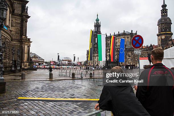 People look over the empty place on front of the Semperoper where the official cermony to mark German Unity day took place on October 3, 2016 in...