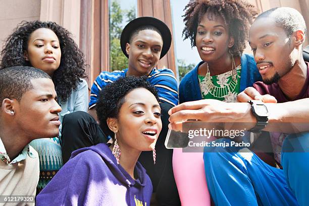 group of friends sharing text messages - cotilleo fotografías e imágenes de stock