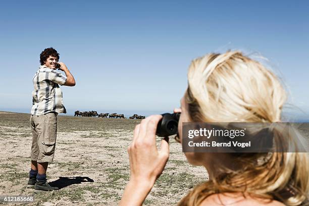 couple watching herd of wildebeests - pantacourt photos et images de collection