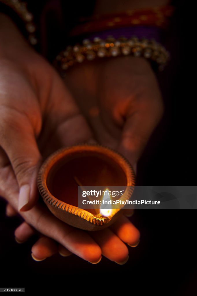 Hands holding a diya