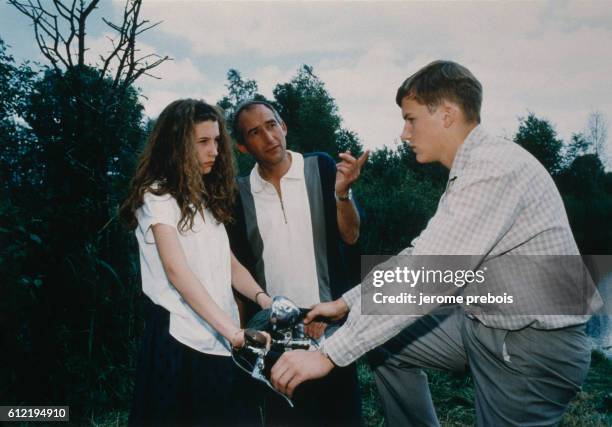 American actress Alicia Silverstone and French actor Nicolas Chatel with French director and screenwriter Alain Corneau on the set of his movie Le...