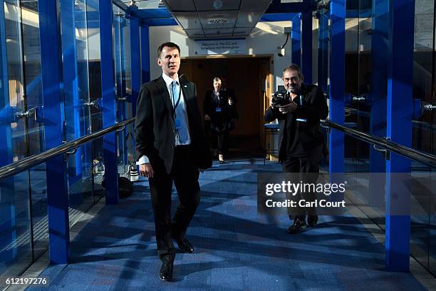 Secretary of State for Health, Jeremy Hunt, talks with a photographer as he walks to his hotel from the conference centre on the second day of the...