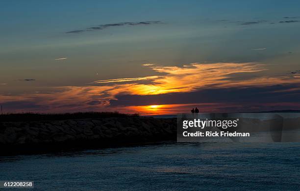 Sunset over Menemsha Sound in the town of Chilmark on Martha's Vineyard, MA over looking beach in the town of Aquinnah, formerly known at Gay Head on...