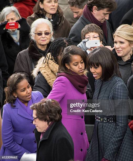 President Barack Obama's oldest daughter Malia, does a little dance next to First Lady Michelle as Sasha looks on arriving for the 57th Inauguration...