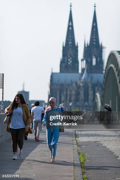 muslim womans walking in front of the cologne cathedral - niqab stockfoto's en -beelden