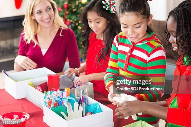 girls pack shoe boxes for christmas charity project - shoe box stock pictures, royalty-free photos & images