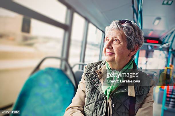 seniorin im bus - öffentliches verkehrsmittel stock-fotos und bilder