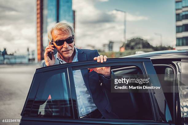 busy man talking on phone - red suit stockfoto's en -beelden