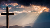 Jesus Christ wooden cross on a dramatic, colorful sunset