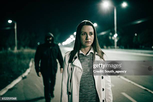 robber walking behind a girl - following bildbanksfoton och bilder