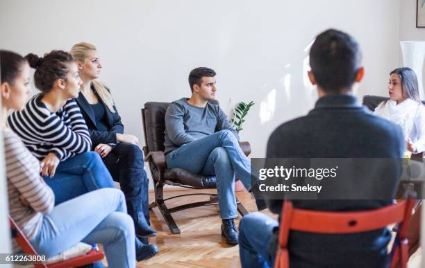 woman speaking in group therapy session - group counselling stock pictures, royalty-free photos & images