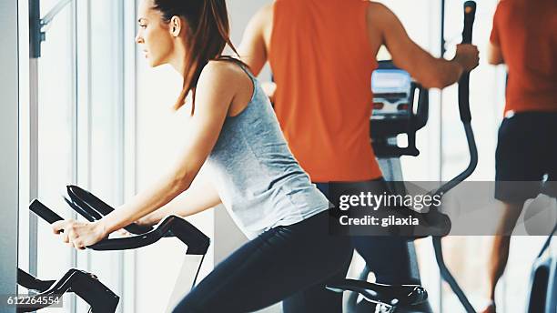 bike exercising in a gym. - sweat stain gym stock pictures, royalty-free photos & images