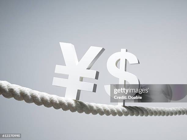 us and yen signs on rope - yen sign stock pictures, royalty-free photos & images