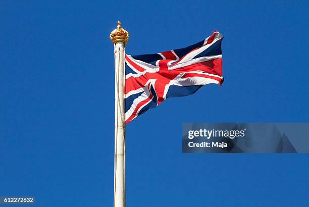 union jack against blue sky - palácio de buckingham imagens e fotografias de stock