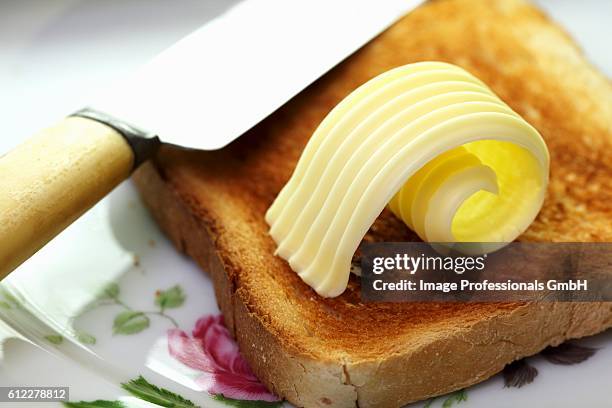 a slice of toast with a curl of butter - butter curl stock pictures, royalty-free photos & images