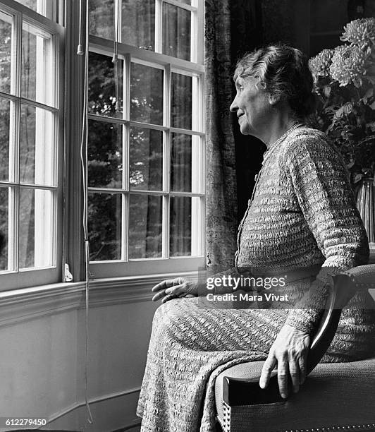 Teacher and author Helen Keller rests beside a window in a sitting room. Keller achieved wide recognition by overcoming blindness and deafness to...