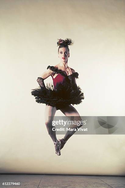 Ballet dancer, Beatrice Thompkins, jumps wearing a red tutu.