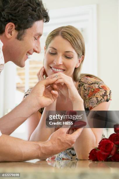 husband presenting jewelry to his wife - men rings foto e immagini stock