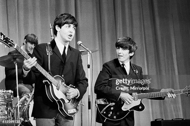 The Beatles on Sunday Night at the London Paldium. Paul McCartney and George Harrison singing and playing their guitars rehearse for the Royal...