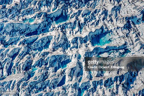 Ponds of water from melting ice at the Knik Glacier in Alaska. Lack of snow-cover expose the ash fallout from the nearby Redoubt Volcano, reducing...