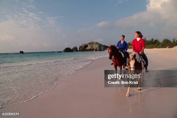 couple horseback riding on bermuda beach - bermuda beach stock-fotos und bilder