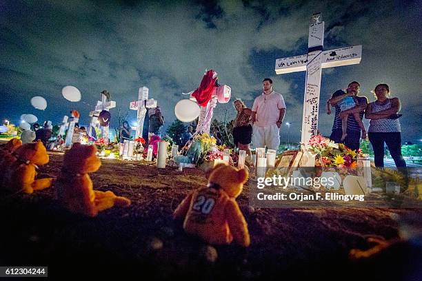 Thousands of people gathered at the improvised memorial across the street from the Century 16 Movie Theater after a vigil was held for the killed and...