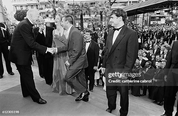 Gilles Jacob stands at the entry of the Palais des Festivals to greet Jacques Audiard, Sandrine Kiberlain, Mathieu Kassovitz and Albert Dupontel,...