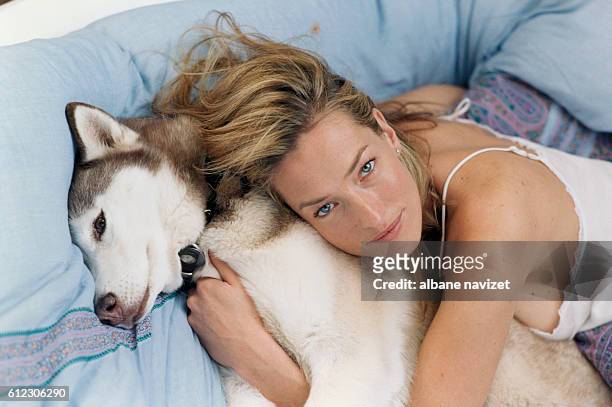 German model and actress Tatjana Patitz at home with her husky dog.