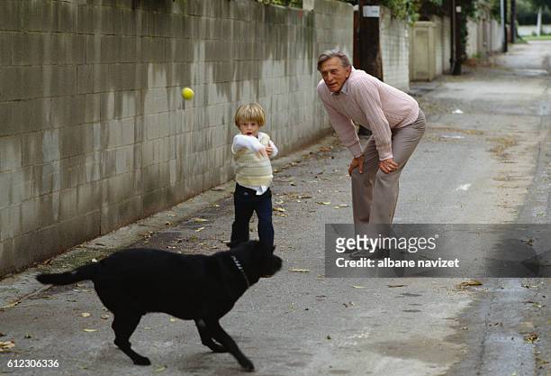 American actor Kirk Douglas plays with his grandson Cameron, the son of actor Michael and Diandra Douglas.