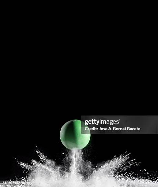 explosion of dust particles by the impact of a ball on a black background - ballon rebond stock-fotos und bilder