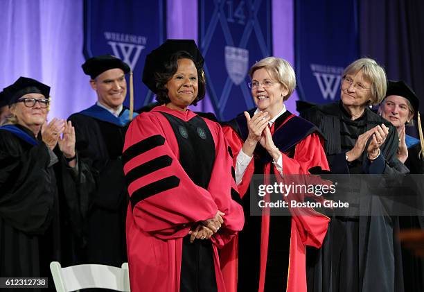 Paula A. Johnson, the new president of Wellesley College, center, stands while the crowd applauds for her at her inauguration ceremony at the school...