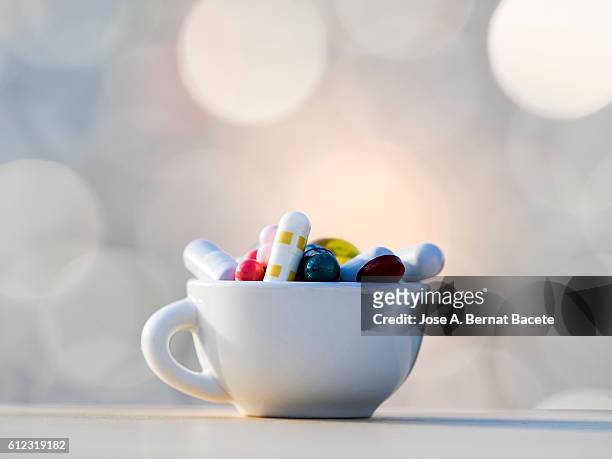 heap of medicines in tablets and pills of colors, inside in a cup of coffee - ビタミンb3 ストックフォトと画像