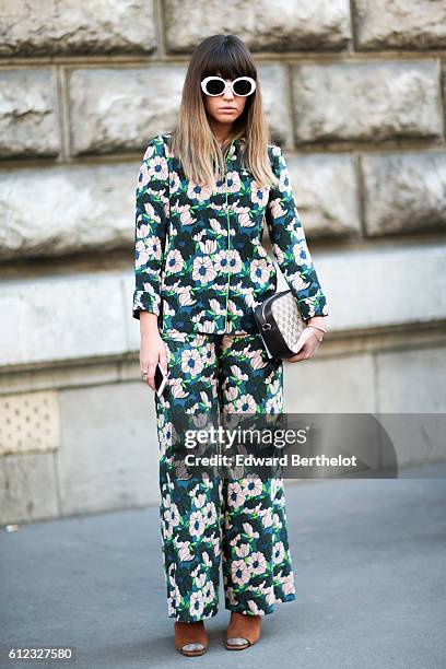 Guest wears a green full outfit with printed flowers, outside of the Hermes show during Paris Fashion Week Spring Summer 2017, on October 3, 2016 in...